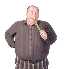 Image showing Fat man enjoying a lollipop