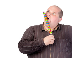 Image showing Fat man enjoying a lollipop