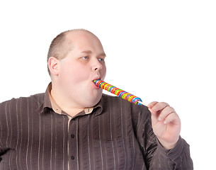 Image showing Fat man enjoying a lollipop