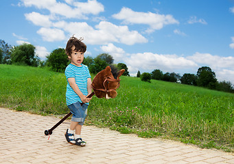 Image showing kid playing with horse stick