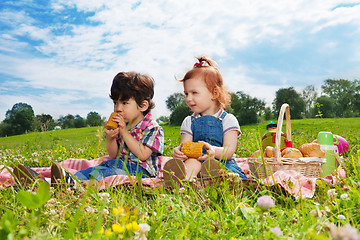 Image showing two cute kids eating lunch on picnic