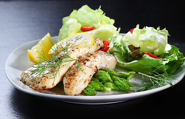 Image showing Fish on green asparagus with salad