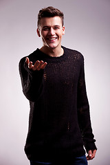 Image showing casual man in a sweater welcoming