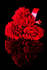Image showing three roses on black background