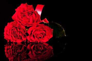 Image showing three roses on black background