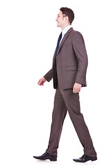Image showing  side view of a young businessman walking