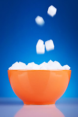 Image showing sugar cubes falling in an orange bowl 