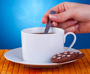 Image showing woman stiring in a fresh cup of coffee