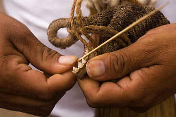 Image showing Sharpening a blowgun dart