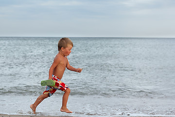 Image showing Little boy running at the seashore