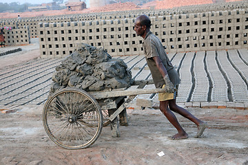 Image showing Brick field. Laborers are carrying deposited soil for making raw brick. in Sarberia, West Bengal, India.