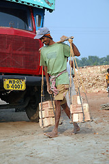 Image showing Brick field workers carrying complete finish brick from the kiln