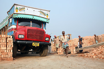 Image showing Brick field workers carrying complete finish brick from the kiln