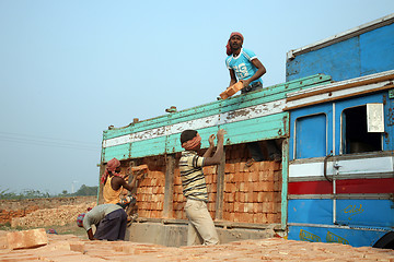 Image showing Brick field workers carrying complete finish brick from the kiln