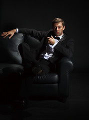 Image showing Handsome man in a tuxedo on couch