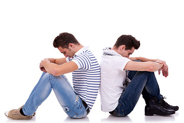 Image showing two sad men sitting back to back