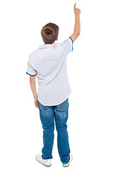 Image showing Rear view of a school boy pointing upwards