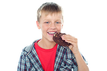 Image showing Fashionable young boy eating chocolate cookie