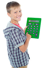 Image showing Pleasant young student using a large green calculator