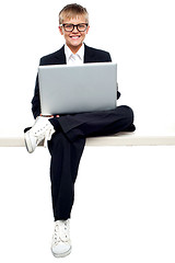 Image showing Smartly dressed young kid working on a laptop