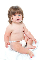 Image showing Cute baby girl sitting up wearing a diaper