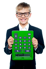 Image showing School boy holding calculator upside down