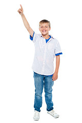 Image showing Charming casual boy pointing upwards