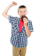 Image showing Boy cheering and enjoying choco chip cookie