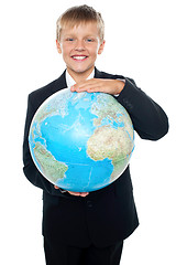 Image showing Cheerful boy in suit holding globe with both hands