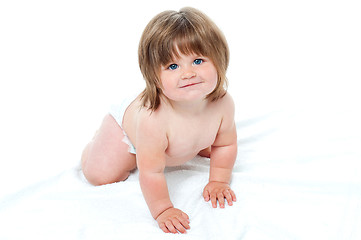 Image showing Charming toddler in diapers trying to crawl