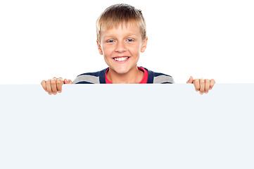 Image showing Stylish boy standing behind big blank banner ad