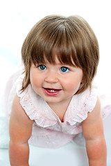 Image showing Baby girl with milk teeth crawling on the ground