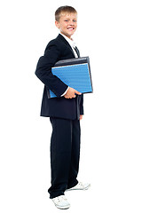 Image showing Smiling kid holding files, young business boy