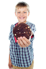 Image showing Happy little young boy holding choco chip cookie