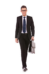 Image showing young business man carrying a suitcase, walking