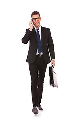 Image showing business man walking and talking on phone