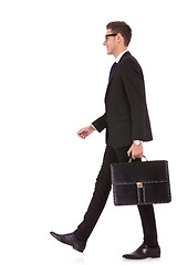 Image showing business man holding brief case and walking