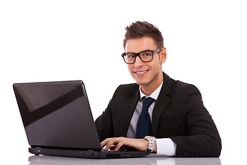 Image showing business man wearing glasses  using a laptop 