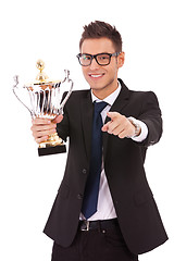Image showing  business man holding a trophy and pointing 
