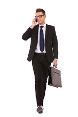 Image showing business man walking and talking on phone