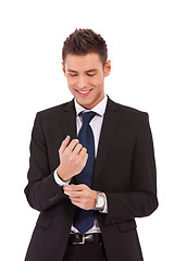 Image showing smiling business man buttoning his sleeve