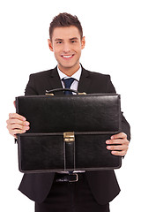 Image showing business man offering a black briefcase 