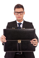 Image showing serious business man offering a briefcase