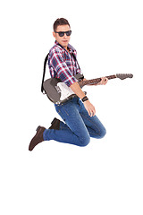 Image showing passionate guitarist jumps in the air 