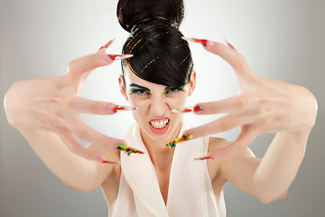 Image showing angry brunette girl shows her finger nails