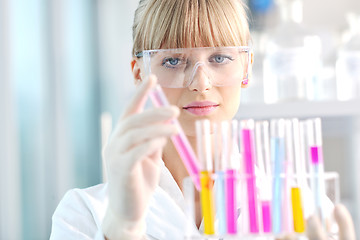 Image showing female researcher holding up a test tube in lab