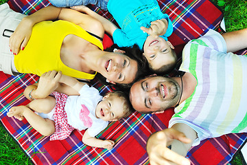 Image showing happy young couple with their children have fun at park