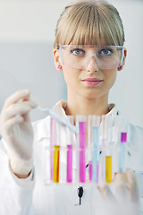 Image showing female researcher holding up a test tube in lab