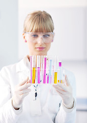 Image showing female researcher holding up a test tube in lab