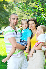 Image showing happy young couple with their children have fun at park